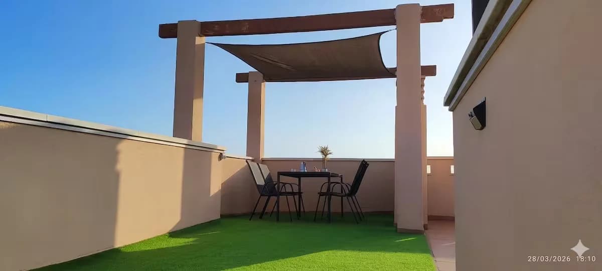 Terraza superior privada con pérgola y comedor