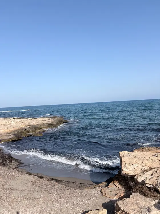 Cala de las Pulgas, un entrante pequeño de grava entre salientes de roca, con el agua turquesa a la orilla