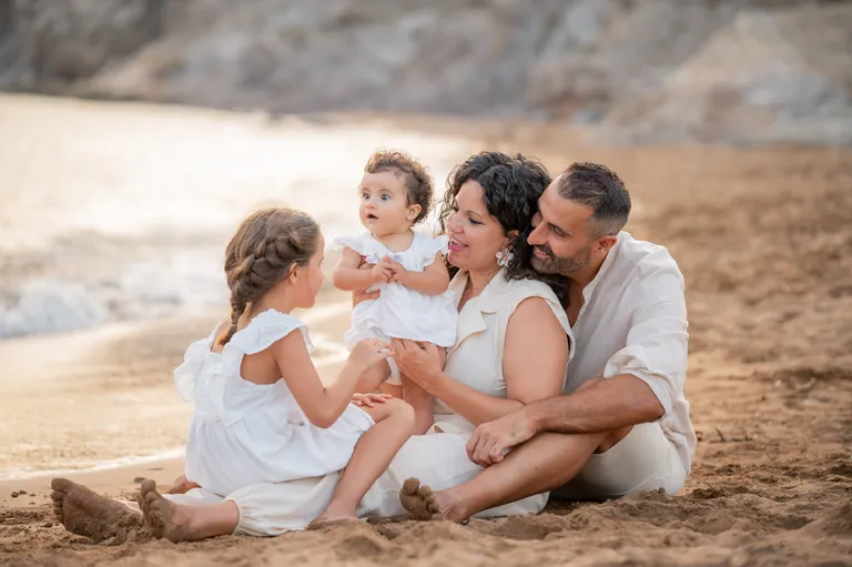 Family sitting on the beach, photograph by Carlos Norte